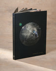 Cover Image of the book ARQUIVISTAS by the Dorow Collection. Cover shows an Enhydro Quartz Sphere suspended in the middle of deep black background.